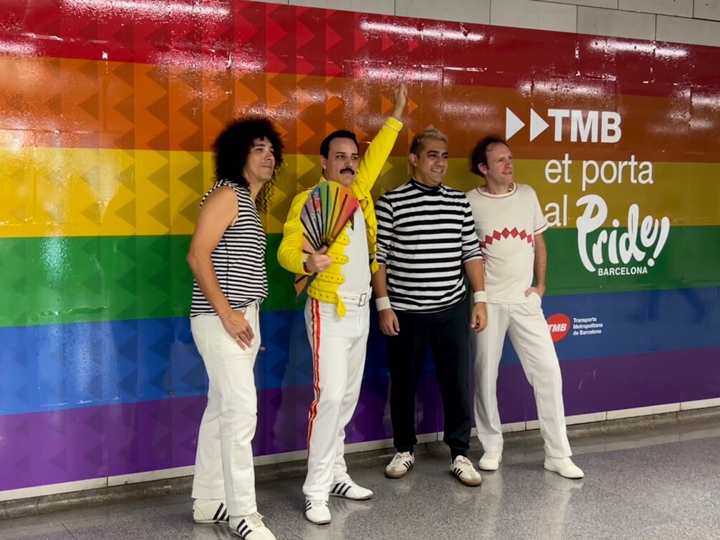 Els integrants de la banda posen davant del vinilat de Pride Barcelona i TMB a l'estació d'Universitat L1 / Foto: Marta Espinosa (TMB)
