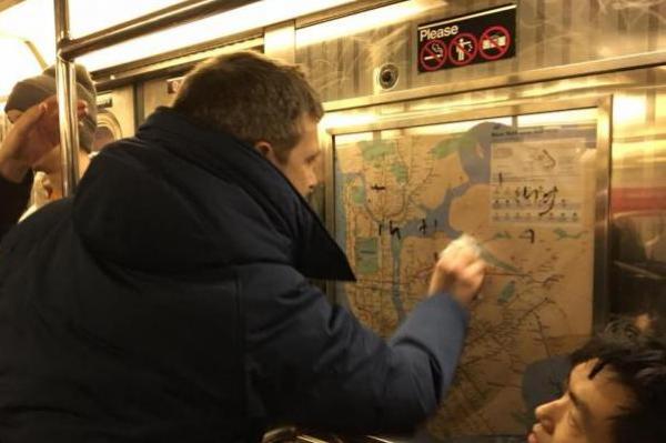 Passatger del metro de Nova York esborrant esvàstiques / Foto: Gregory Locke (Facebook)