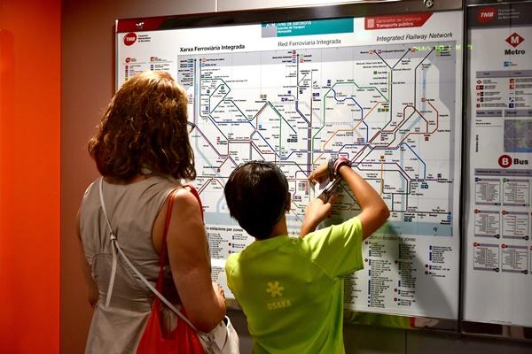 usuaris consultant el plànol de la xarxa ferroviària integrada en una estació de la línia 10 Sud / Foto: Pep Herrero (TMB)