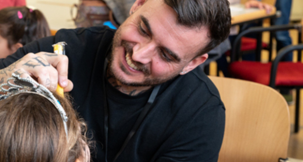 Un voluntari participant en l'activitat de maquillatge per a nens i nenes