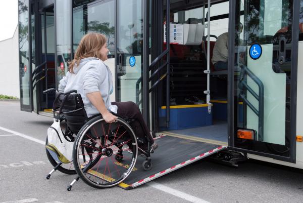Una usuària amb cadira de rodes entrant en un bus gràcies a la rampa d'accés.