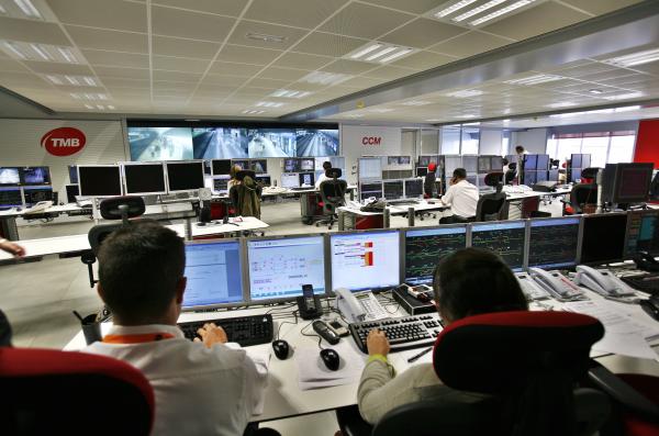 Interior del Centre de Control de Metro amb empleats treballant i el videowall amb el seguiment dels trens.